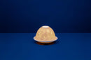 A white unglazed porcelain tealight holder with a dome cover, featuring a lithophane design that creates a golden pattern when lit from within.